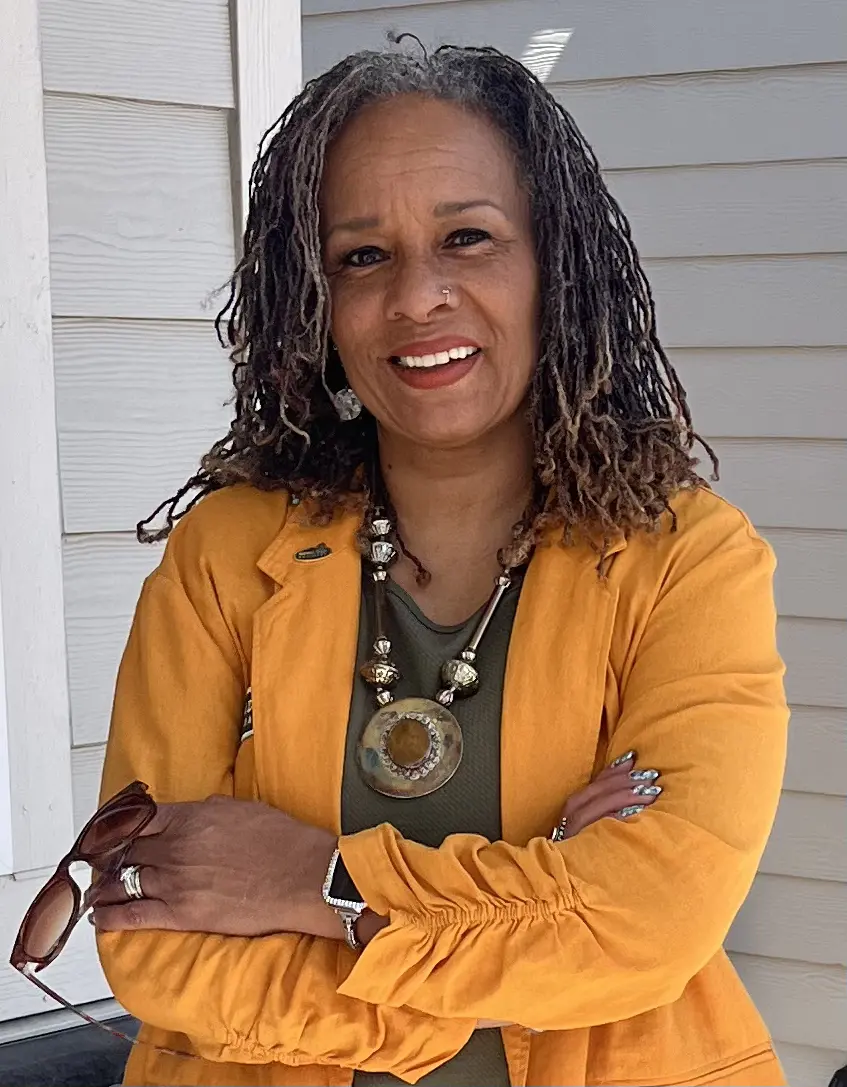Beverly Brown, arms folded, smiling